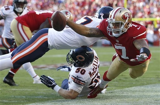 San Francisco 49ers quarterback Colin Kaepernick (7) is pushed out of bounds by Chicago Bears free safety Chris Conte, top, as Shea McClellin helps on defense during the first quarter of an NFL fo ...
