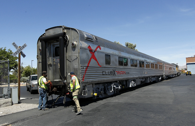 Union Pacific workers prepare a pair of Club X Train cars to be removed from the Las Vegas Review-Journal's parking lot near the intersection of MLK Blvd. and Bonanza Rd. in Las Vegas on Thursday, ...