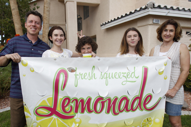 Rock Rocheleau, from left, with his daughters Jordan, 12, Jessica, 10, and Jenna, 12, and his wife Stacy, pose for a portrait with their lemonade sign at their home in Henderson Saturday, Sept. 6, ...