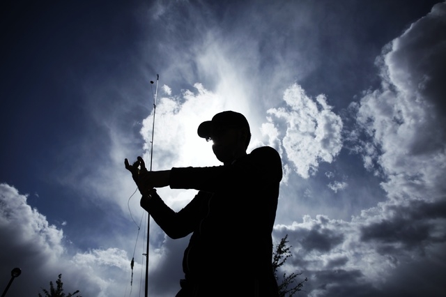 A fisherman, who declined to give his name, fixes his hook while fishing at Lorenzi Park in Las Vegas Wednesday, May 7, 2014. (John Locher/Las Vegas Review-Journal)