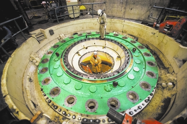 Kevin Zito, top, hands  David Polan a grinder while then prep for a turbine installation at Hoover Dam on Thursday, March 20, 2014.Almost two-fifths of the workforce at the federal facility is exp ...