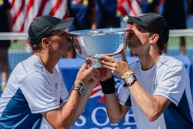 Bob Bryan (L) and his brother Mike Bryan of the U.S. kiss their trophy after they defeated Marcel Granollers and Marc Lopez of Spain in their men's doubles final match at the 2014 U.S. Open tennis ...