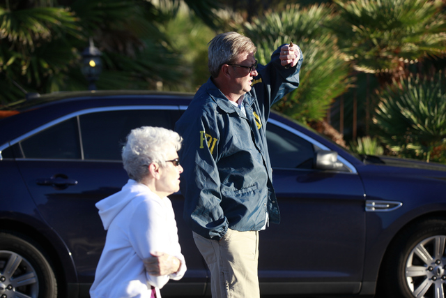 Neighborhood resident Myrna Cameron questions an unidentified FBI official as the FBI investigates while serving a federal search warrant at a home at 4311 E. Oquendo Road in Las Vegas on Monday,  ...