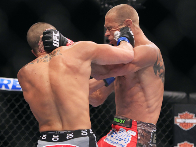 Donald Cerrone gets hit with a right from Eddie Alvarez during their fight at UFC 178 Saturday, Sept. 27, 2014 at the MGM Grand Garden Arena in Las Vegas. Cerrone won by unanimous decision. (Sam M ...