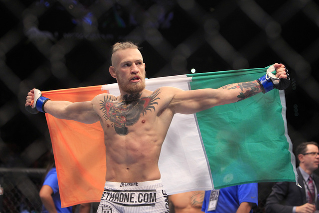 Conor McGregor holds the Republic of Ireland flag after defeating Dustin Poirier by TKO in their fight at UFC 178 Saturday, Sept. 27, 2014 at the MGM Grand Garden Arena in Las Vegas. (Sam Morris/L ...