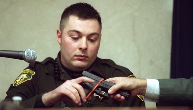 Metro Police officer Brian Yant is handed a weapon during  a court hearing on January 3, 2002. (Clint Karlsen/Las Vegas Review-Journal file)