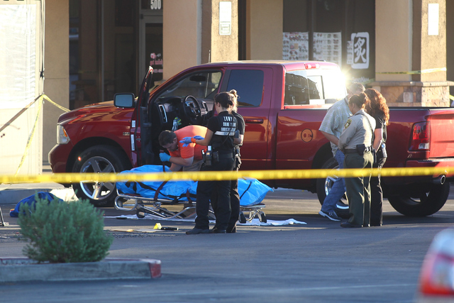 Officials from the Clark County coroner's office prepare to transfer the body of a shooting victim early Monday morning, Sept. 15, 2014. Las Vegas police are investigating the homicide at a strip ...