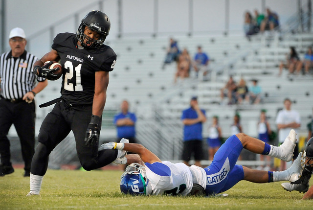 Palo Verde's Jaren Campbell (21) is tripped up by Green Valley's Jacob Rivero during the first half of a high school football game at Palo Verde High School on Friday, Sept. 5, 2014. (Photo by Dav ...