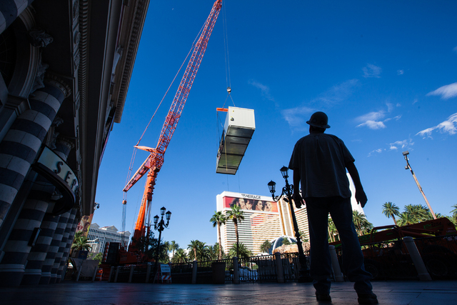 John Hillier of Hansen Mechanical, right, watches as part of a new central plant, center, is lifted by a crane as renovations go on at the Best Western Plus Casino Royale in Las Vegas on Wednesday ...