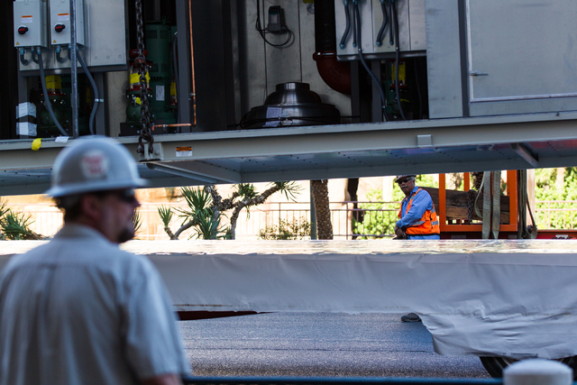 Workers watch as part of a new central plant, above, is lifted by a crane as renovations go on at the Best Western Plus Casino Royale in Las Vegas on Wednesday, Sept. 17, 2014. Northbound lanes on ...