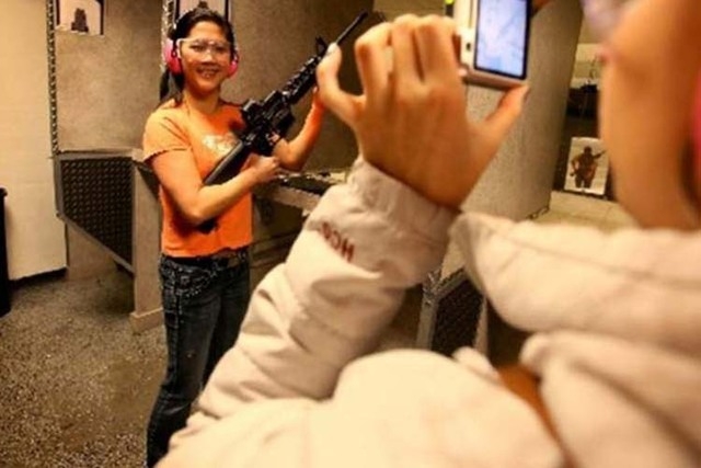 Guik Chin of Ottawa, Canada, poses for a photo Wednesday while holding a Beretta CX4 semiautomatic rifle at The Gun Store.