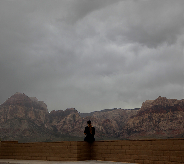 A woman looks at the clouds from an observation area in  Red Rock National Conservation Area on Sunday, Sept. 7, 2014. Rain and wind swept through the valley as the remnants of tropical storm Norb ...