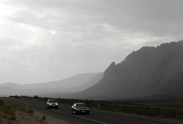 Cars travel along on State Route 157 during a rain shower in Red Rock National Conservation Area on Sunday, Sept. 7, 2014. Rain and wind swept through the valley as the remnants of tropical storm ...