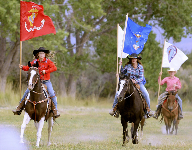 Patrice Stewart with Marine Corps flag, from left, Katelyn Rose with NV flag and Quint Bell with another service flag make a grand entry at the Ninety-Six Ranch NV 150 Celebration on August 9, 201 ...