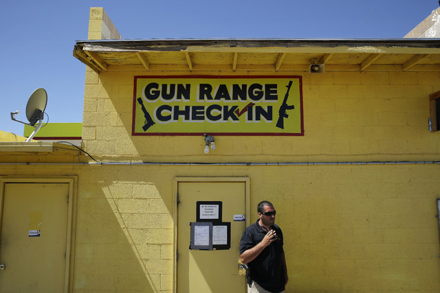 An employee smokes outside of an office for the Last Stop outdoor shooting range Wednesday, Aug. 27, 2014, in White Hills, Ariz. Instructor Charles Vacca was accidentally killed at the range by a ...