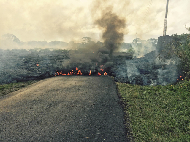 The lava flow from the Kilauea Volcano is seen crossing Apa'a Street/Cemetery Road near the village of Pahoa, Hawaii, Saturday, Oct. 25, 2014. (Reuters/U.S. Geological Survey handout)