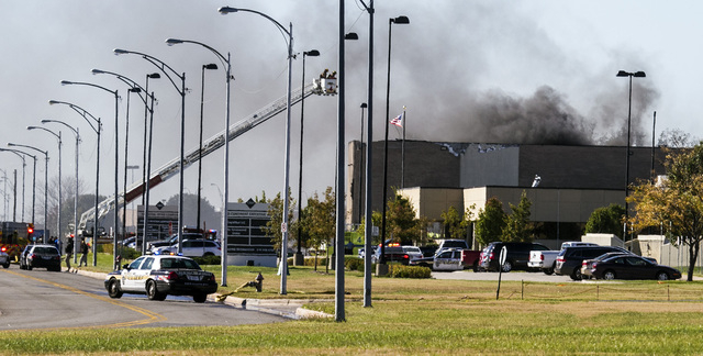 Firefighters try to put out a fire in a building near Mid-Continent Airport in Wichita, Kansas, Thursday, Oct. 30, 2014, shortly after a small plane crashed into the building, killing several peop ...