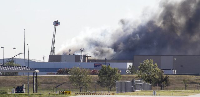 Firefighters try to put out a fire in a building near Mid-Continent Airport in Wichita, Kansas, Thursday, Oct. 30, 2014, shortly after a small plane crashed into the building, killing several peop ...