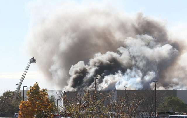 Smoke billows from a building at Mid-Continent Airport in Wichita, Kansas, Thursday. Oct. 30, 2014, shortly after a small plane crashed into the building, killing several people including the pilo ...