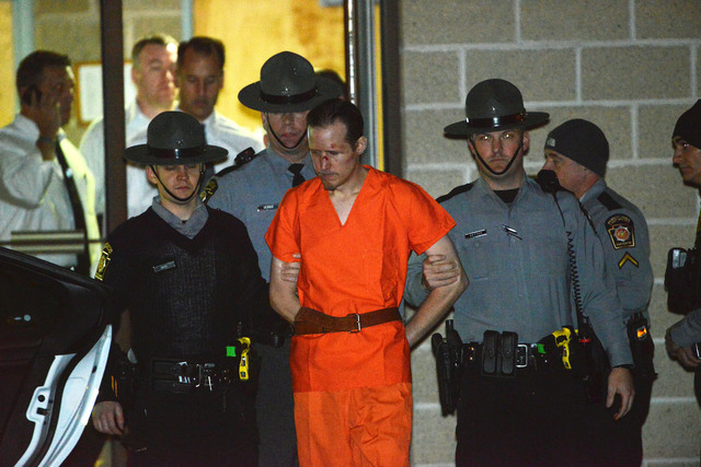 State troopers escort Eric Matthew Frein from the Blooming Grove barracks early Friday, Oct. 31, 2014. Frein, accused of opening fire on the barracks Sept. 12, killing state police Cpl. Bryon K. D ...