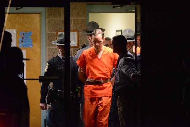 State troopers escort Eric Matthew Frein from the Blooming Grove barracks early Friday Oct. 31, 2014. Frein, accused of opening fire on the barracks Sept. 12, killing state police Cpl. Bryon K. Di ...