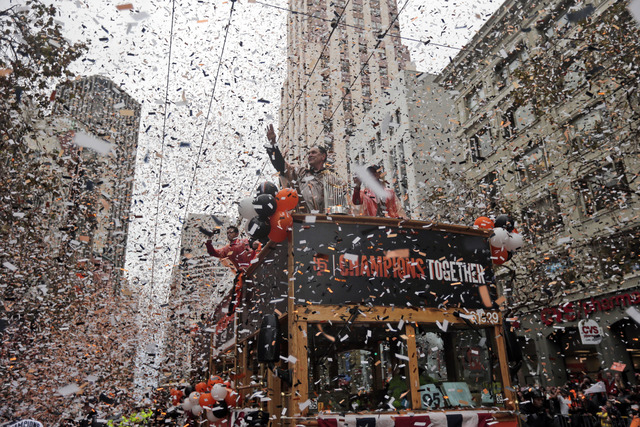 San Francisco Giants manager Bruce Bochy, top center, waves as he carries the 2014 World Series trophy during the victory parade for baseball's 2014 World Series champions, Friday, Oct. 31, 2014,  ...