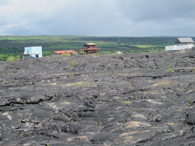 Houses sit among recent lava flow in Kalapana, Hawaii on Thursday, Oct. 30, 2014. Ten miles from Pahoa, the small Hawaii town held hostage by a slowly oozing stream of lava from Kilauea volcano, p ...