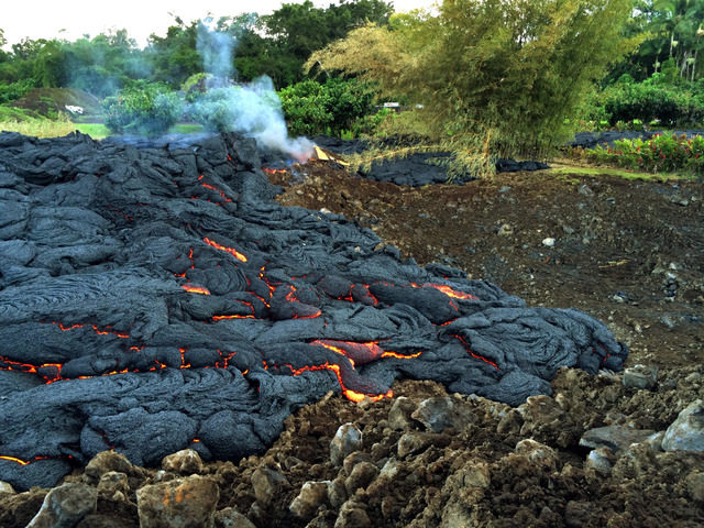 This Oct. 30, 2014 photo from the U.S. Geological Survey shows a breakout of lava oozing from the margin of the lava flow near the town of Pahoa on the Big Island of Hawaii. These breakouts are lo ...