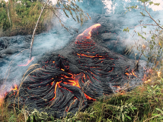 This Oct. 30, 2014 photo provided by the U.S. Geological Survey shows lava flow burning vegetation near the town of Pahoa on the Big Island of Hawaii. The Hawaii National Guard is deploying troops ...