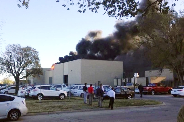 Black smoke billows from a building at Mid-Continent Airport where officials say a plane crashed Thursday, Oct. 30, 2014, in Wichita, Kansas. (AP Photo/KAKE News)