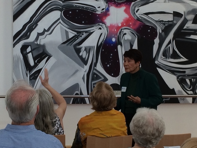 Three-year docent Anita Daus discusses a 20-foot by 10-foot painting by James Rosenquist. (Linda Simpson/View)