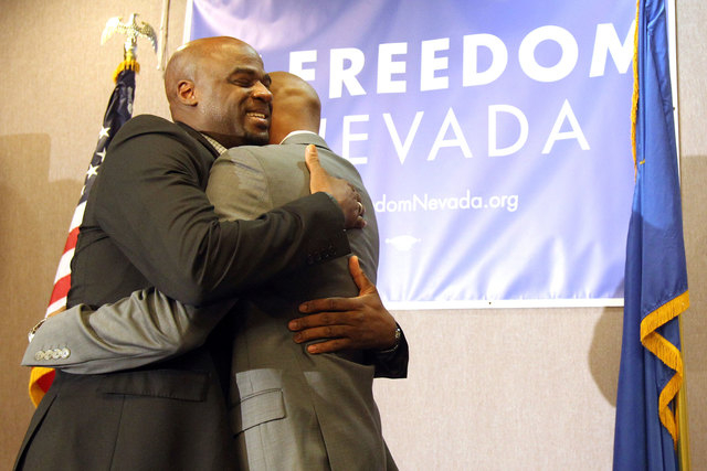 Nevada state Senator Kelvin Atkinson, left, hugs his fiance Sherwood Howard after proposing during a celebration of the 9th U.S. Circuit Court of Appeals on ruling Tuesday, Oct. 7, 2014, finding N ...