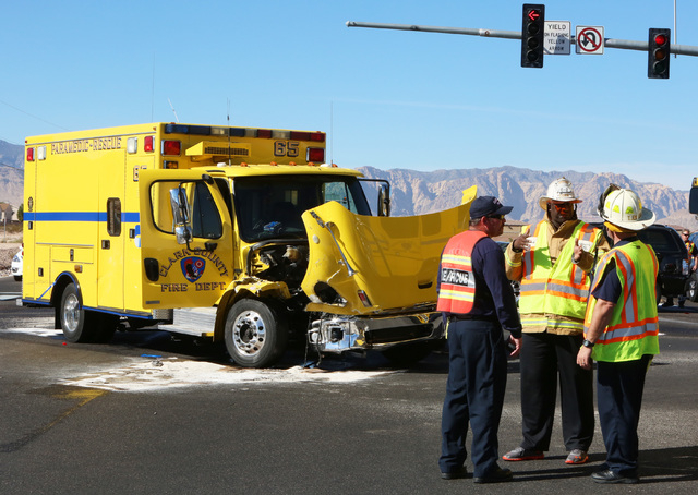 Clark County emergency workers stand at the accident scene where a Clark County fire truck and an SUV collided at the intersection of Blue Diamond Road and Durango Drive on Friday, Oct. 31, 2014. ...