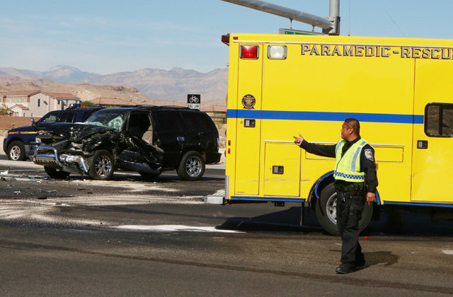 Las Vegas police officer directs traffic at the intersection of Blue Diamond Road and Durango Drive where a Clark County fire truck and an SUV collided on Friday, Oct. 31, 2014. Four people were t ...