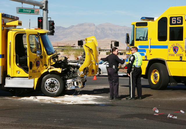 Las Vegas police officers are seen at the accident scene where a Clark County fire truck and an SUV collided at the intersection of Blue Diamond Road and Durango Drive on Friday, Oct. 31, 2014. Fo ...