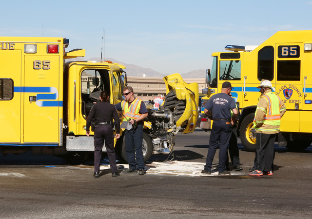 Clark County emergency workers stand at the accident scene where a Clark County fire truck and an SUV collided at the intersection of Blue Diamond Road and Durango Drive on Friday, Oct. 31, 2014.  ...