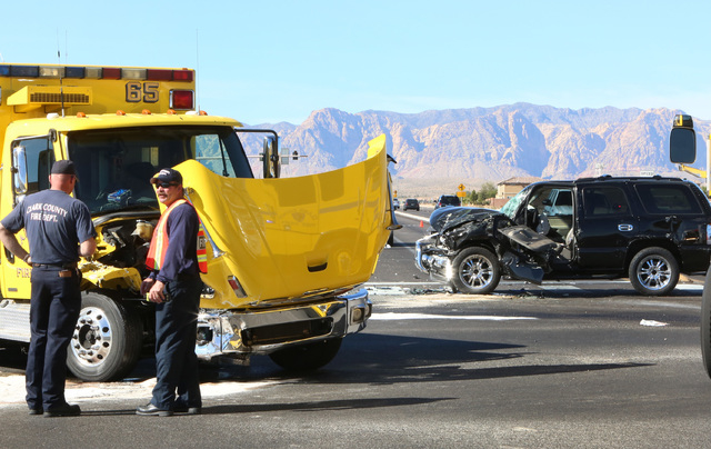 Clark County emergency workers stand at the accident scene where a Clark County fire truck and an SUV collided at the intersection of Blue Diamond Road and Durango Drive on Friday, Oct. 31, 2014. ...