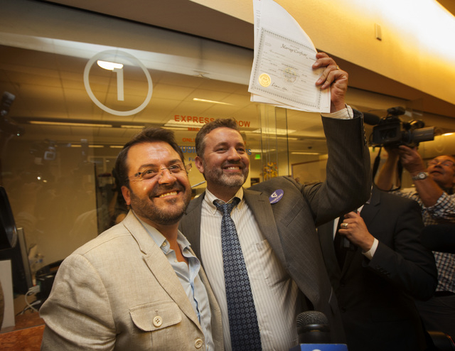 Antioco Carrillo, left and Theo Small celebrate after receiving the first same-sex license in Clark County on Thursday, Oct. 9, 2014at County License Bureau.  United States Federal Judge James C.  ...
