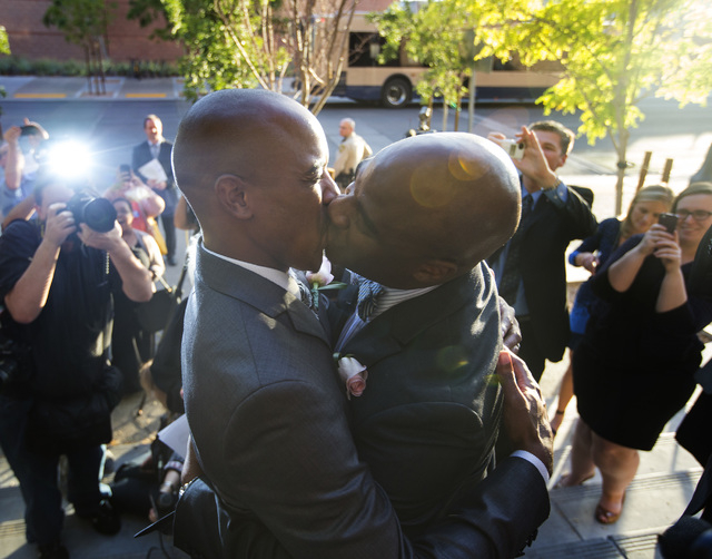 Sherwood Howard, left, and his husband Nevada Sen. Kelvin Atkinson, kiss after after gettingmarried on the steps of the Regional Justice Center on Thursday, Oct. 9, 2014.  They were the first same ...