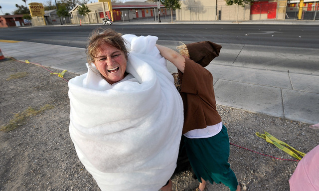 Barbara Kaminski, left, gets final touches to her tornado costume from Ragen Rexfoad, as the scarecrow, before entering the 5th annual Halloween parade along East Fremont Street in Las Vegas on F ...