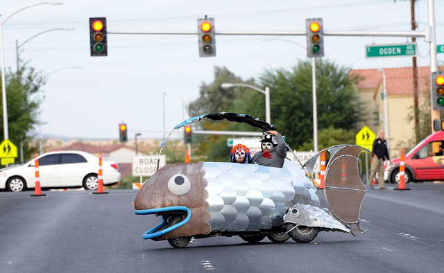 Trina Medina, left, and Mark Cadrin, guide their "SidFishes" vehicle to the start of the 5th annual Halloween parade along East Fremont Street in Las Vegas on Friday, Oct. 31, 2014. (Dav ...