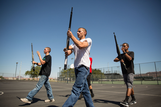 Basic High School Junior ROTC members James Werner, 16, left, Aaron Bates, 16, center, and Kenny Calzada, 17, right, practice their armed drill team program at the high school Friday, Sept. 19, 20 ...