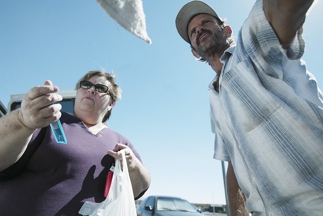 Homeless advocate Linda Lera-Randle El, left, holds a tube of peanut butter for Terry, a homeless man  who washes car windows for a living, as she makes a food delivery stop at Huntridge Circle Pa ...