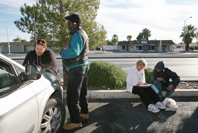 Straight from the Streets director Linda Lera-Randle El, left, issues a bus pass to a homeless man who calls himself Earl in a parking lot near Arizona Charlie's casino in Las Vegas Thursday, Nov. ...