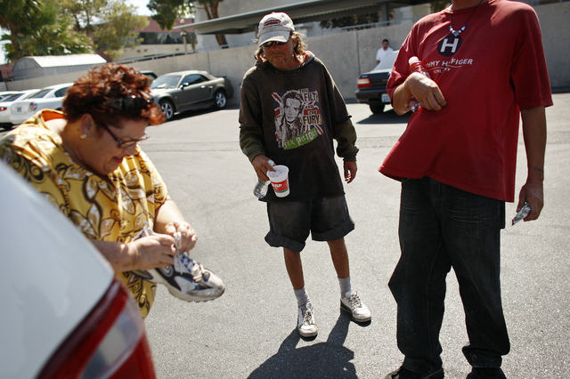Linda Lera-Randle El, left, hands out clothing, food and bus passes to homeless men, continuing from left, Patrick Henry Hamilton, Michael Edwin and Jason Pinkoson on Thursday, July 30, 2009, in L ...