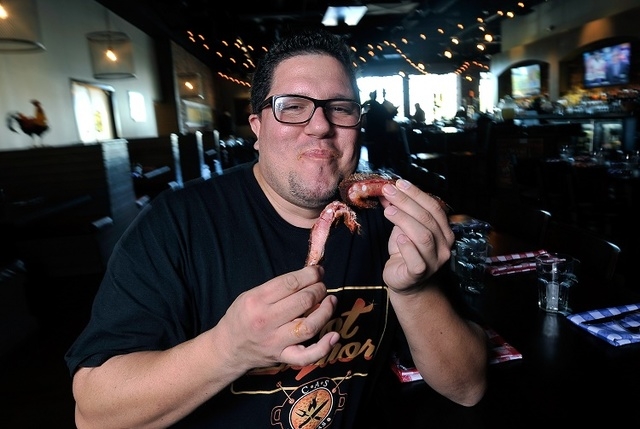 Flip Arbelaez, founder of the new BBQ restaurant, Pot Liquor, samples some freshly smoked ribs inside his recently opened establishment at Town Square Las Vegas on Monday, Oct. 6, 2014. (David Bec ...
