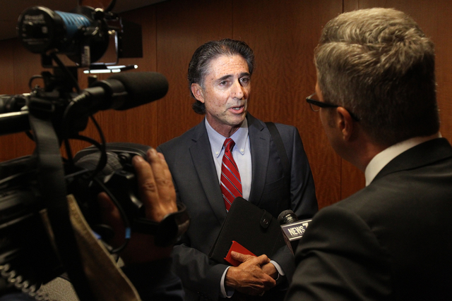 North Las Vegas spokesperson Mitch Fox, center, talks to the news media after a council meeting at City hall Wednesday, Oct. 1, 2014. Animal activists attended the meeting to demand explanations f ...