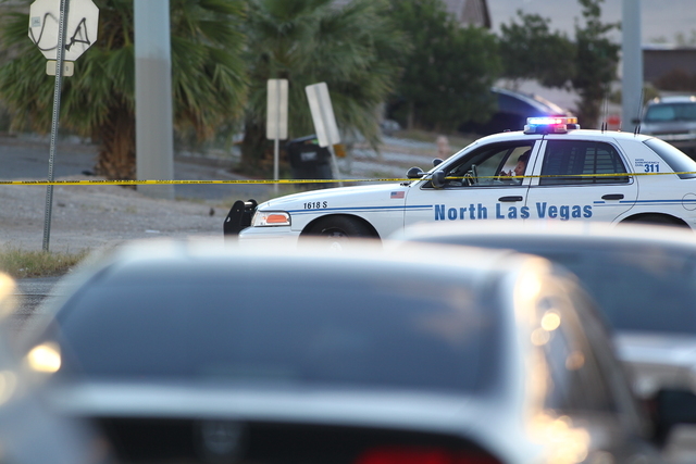 A North Las Vegas police officer sits at the intersection of Miller Avenue and Revere Street Wednesday morning, Oct. 8, 2014. A man was killed and an officer was wounded in a shootout Tuesday nigh ...