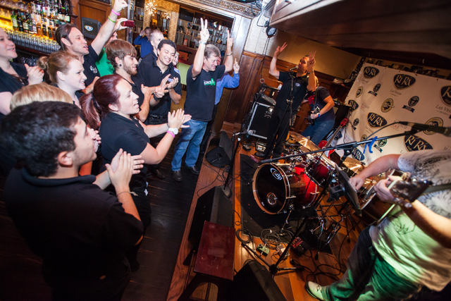 Restaurant staff and supporters cheer and count down before Dave Browne, second from right, and Dave Rooney, right, perform as the first act in a Guinness World Record attempt for Longest Concert ...