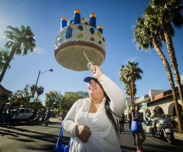 Anna Lynn holds an inflatable birthday cake during the   Nevada Day Parade on Fourth Street in downtown Las Vegas on Friday, Oct. 31. Thousands lined the street to celebrate Nevada's  Sesquicenten ...